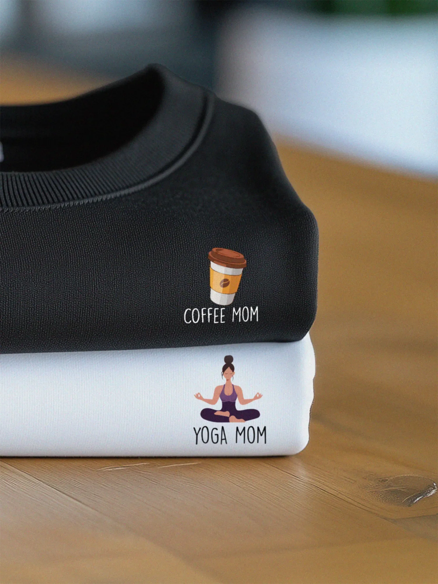 Stack of a black and a white sweatshirts with Mini designs for the Mom Minis collection by inspire.inc