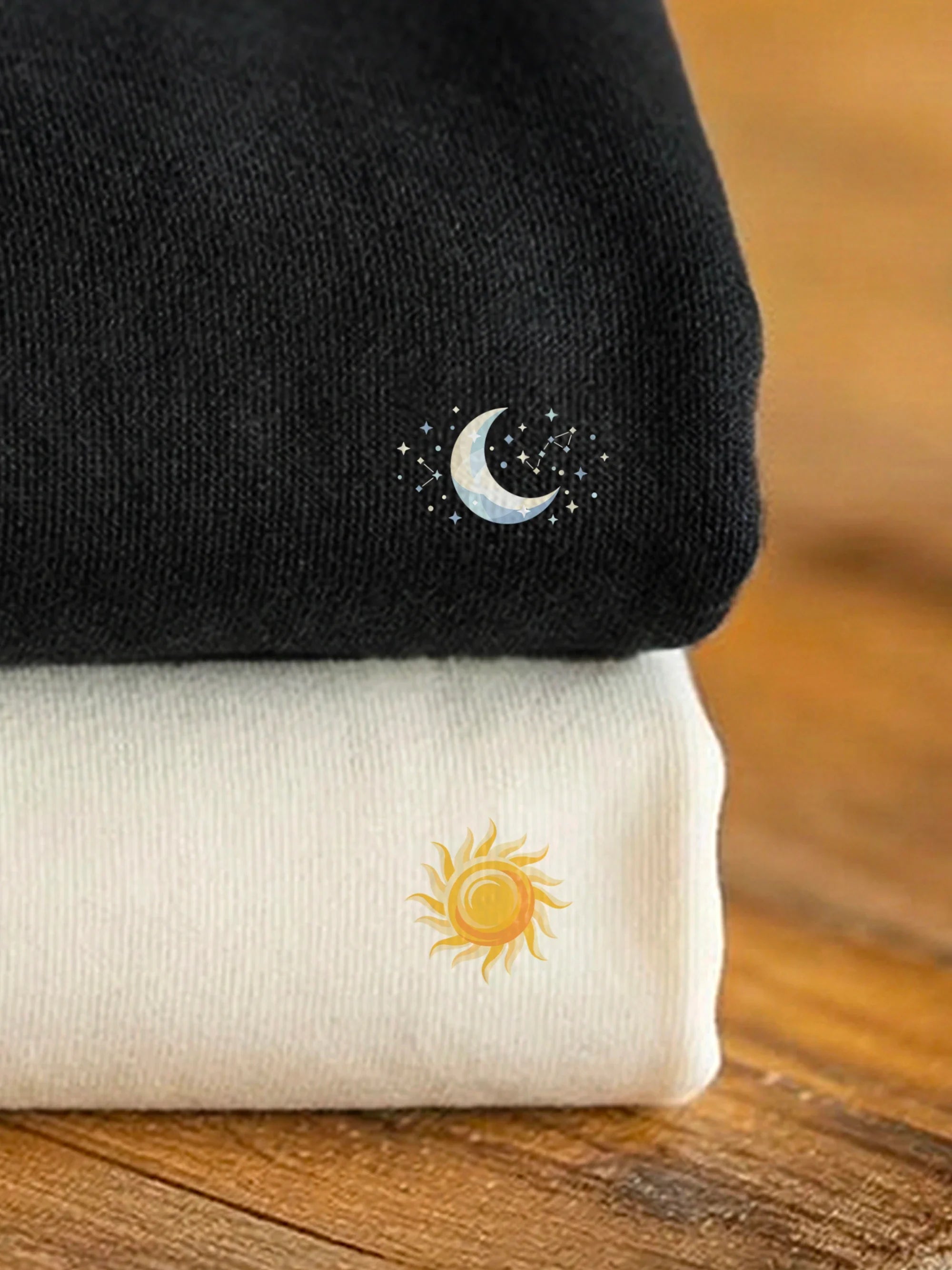 Stacked black and off white sweatshirts with designs from the Perfect Match - Circadian collection by inspire.inc