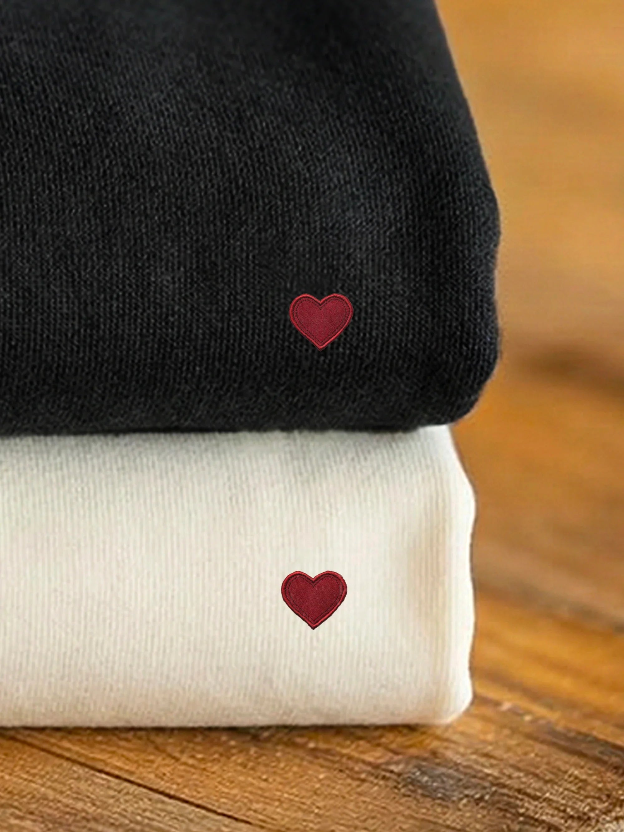 Stacked black and off white sweatshirts with designs from the Perfect Match - Heart To Heart collection by inspire.inc