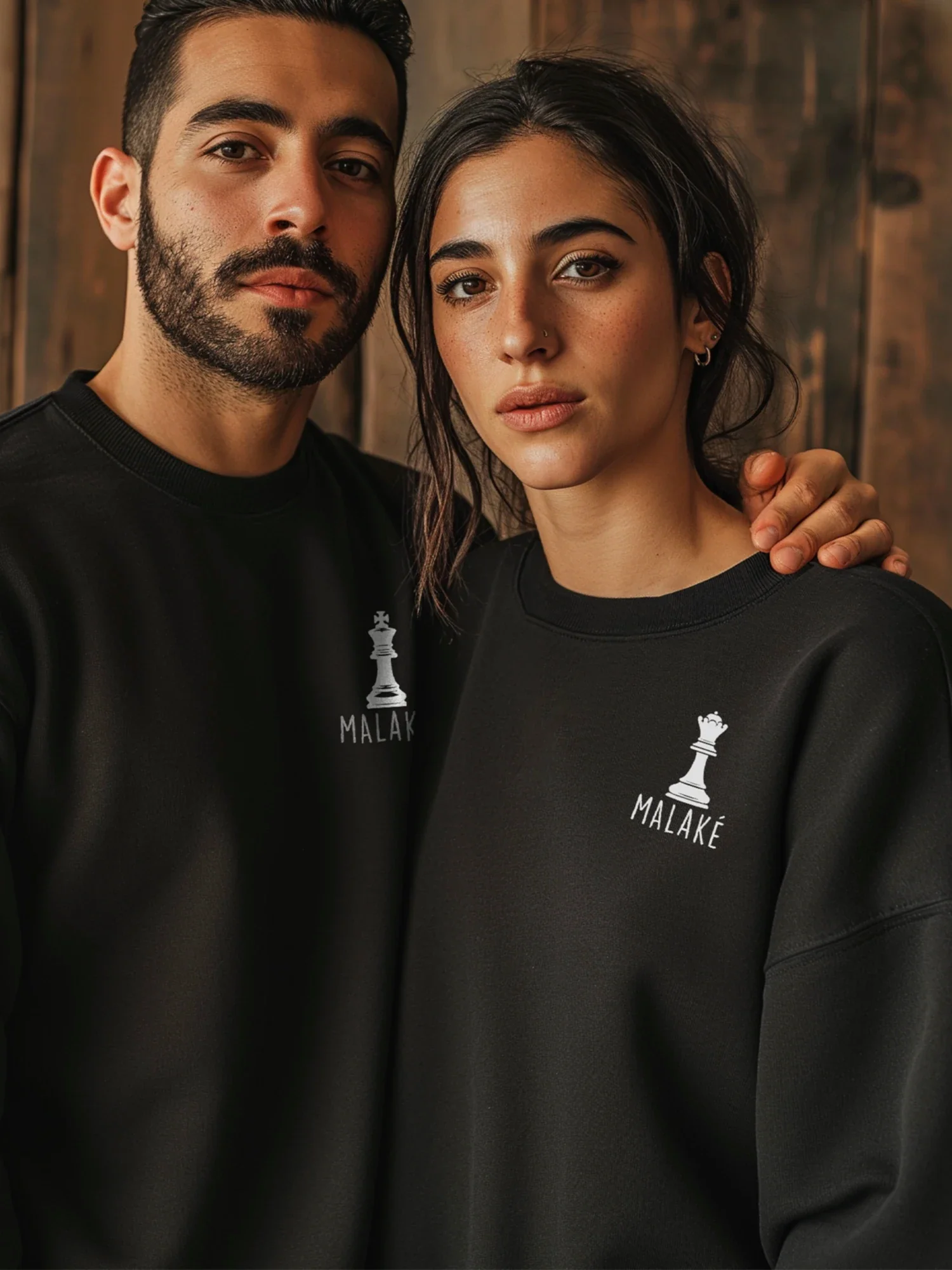 A man and a woman wearing black sweatshirts from the Queens and Kings collection by inspire.inc