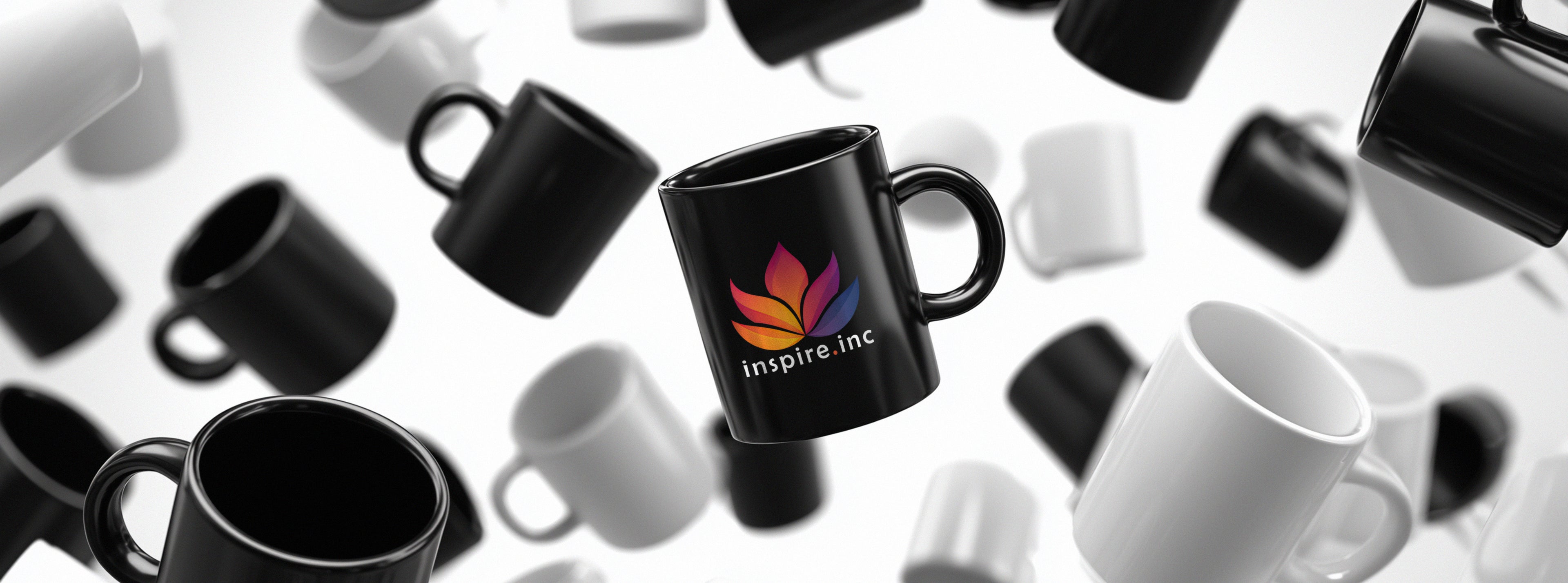 Black mug with a colorful inspire.inc logo surrounded by other mugs by inspire.inc